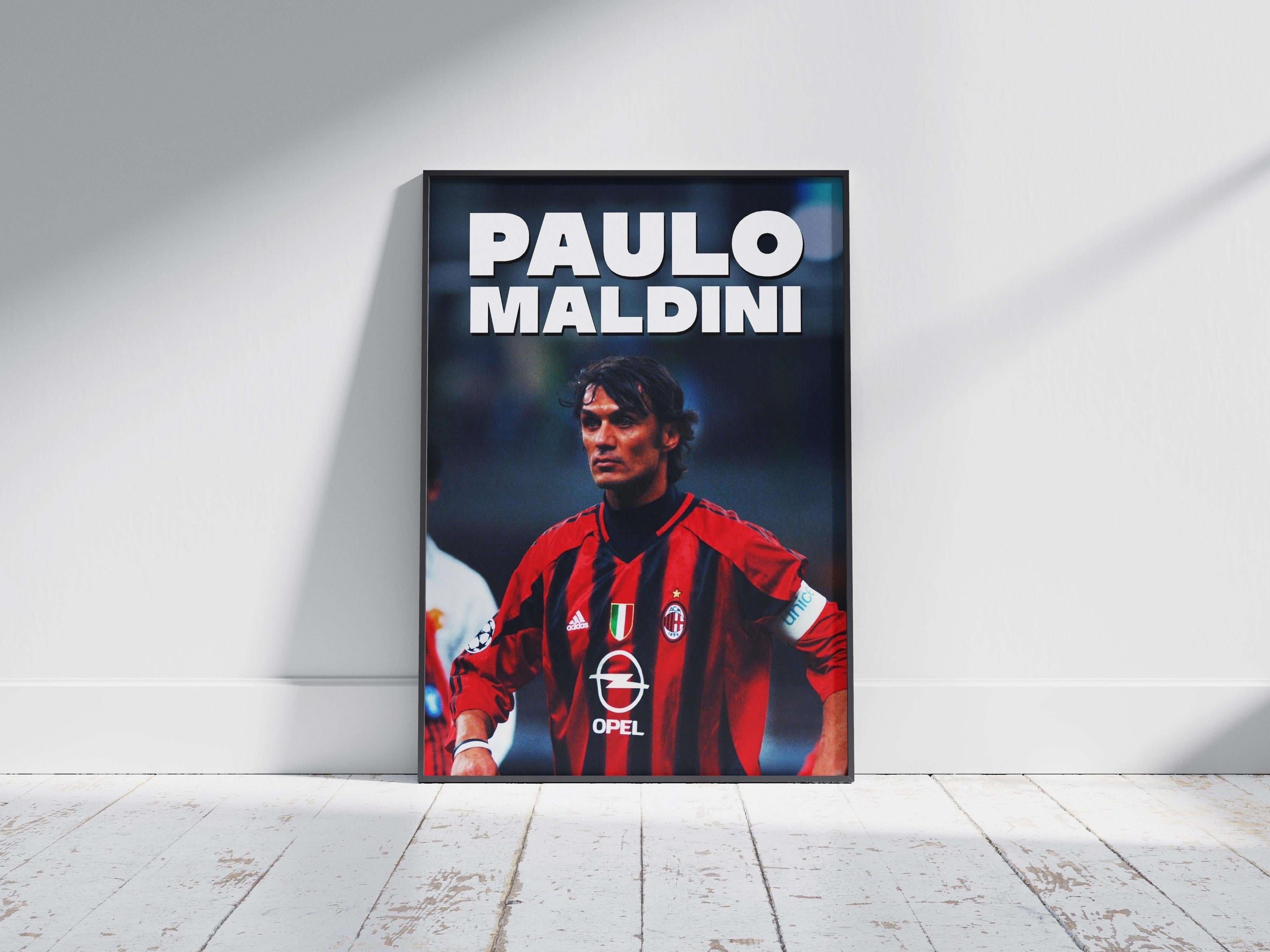 The Retro1999 Paolo Maldini AC Milan Poster features the football legend in a red and black jersey, standing with hands on hips on a white floor. “PAOLO MALDINI” is displayed above, honoring his iconic role in football history.