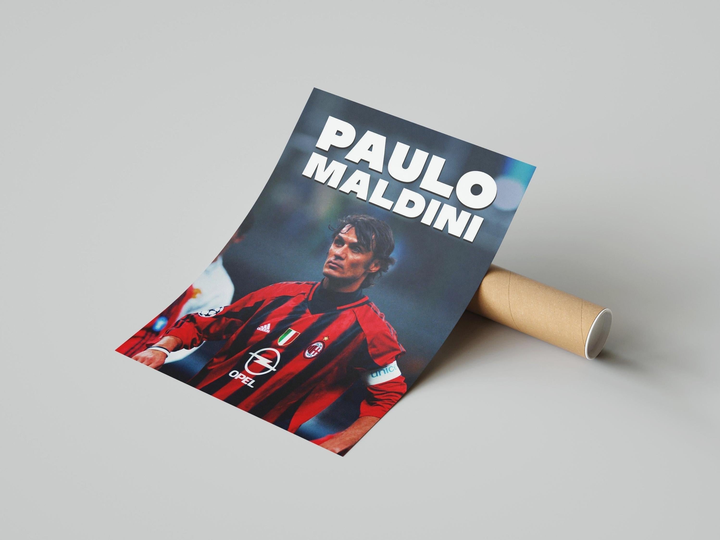 The Retro1999 Paolo Maldini AC Milan Poster shows the legendary captain in red and black, partially unrolled on a gray surface with PAOLO MALDINI in bold white text at the top, celebrating a football icon.