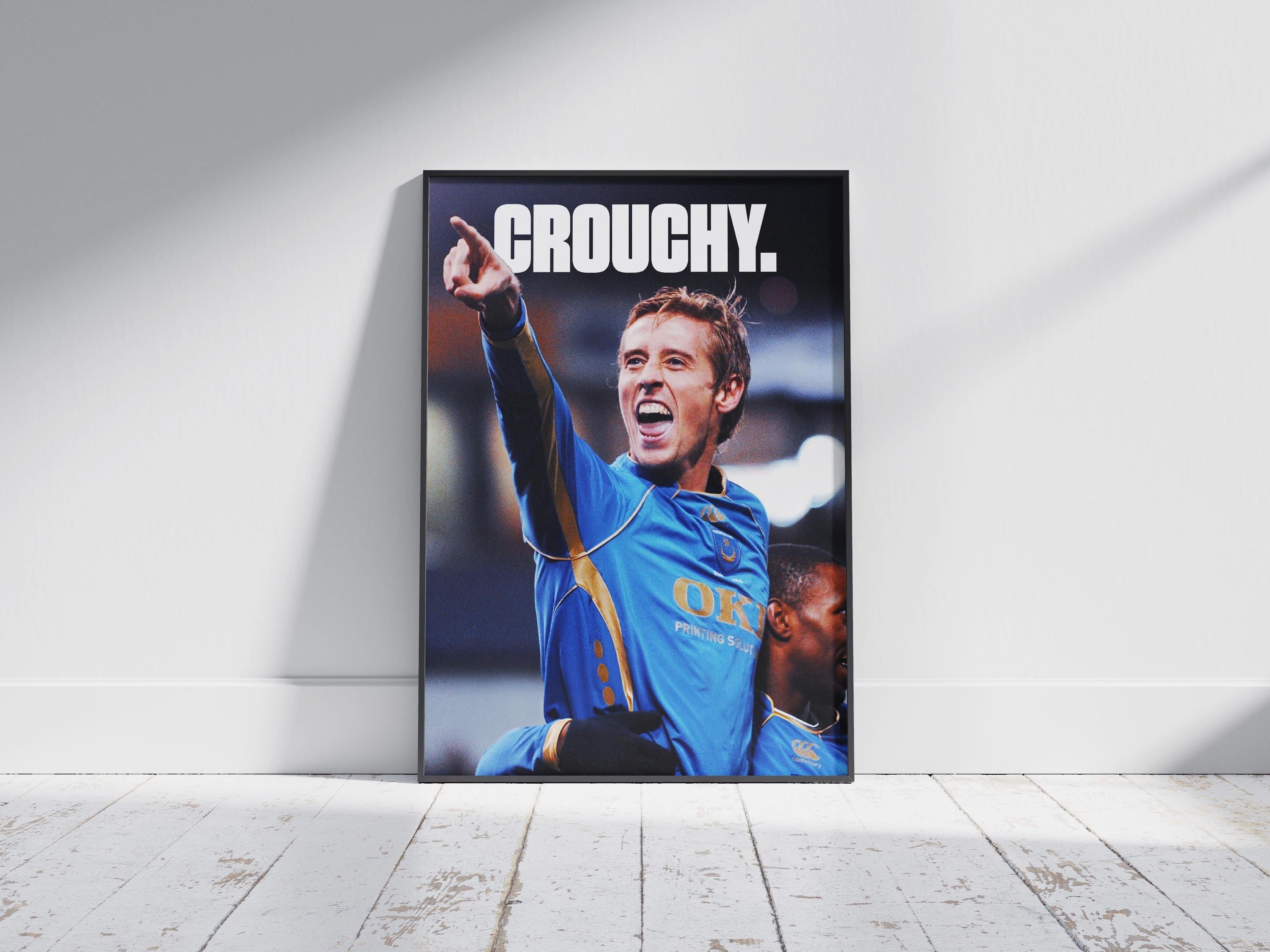 The Retro1999 Peter Crouch x Jermain Defoe Poster shows a soccer player in a blue jersey celebrating on a wooden floor, with bold white “CROUCHY” text at the top, capturing classic English Premier League nostalgia.