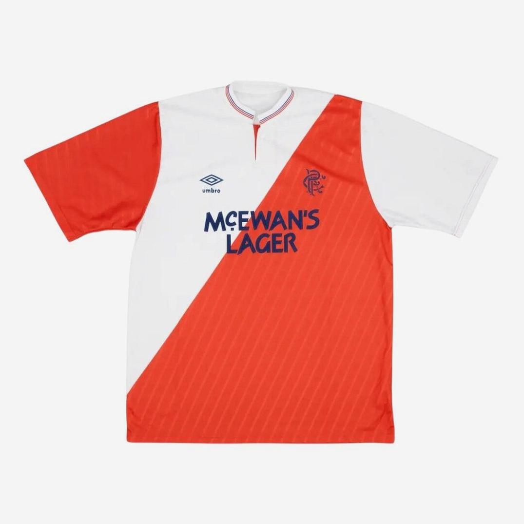 The Retro1999 Rangers F.C. 1987-90 Away Shirt features a white and red diagonal split, navy McEwans Lager sponsor, Umbro logo, and club crest—a classic retro soccer jersey inspired by the original design.