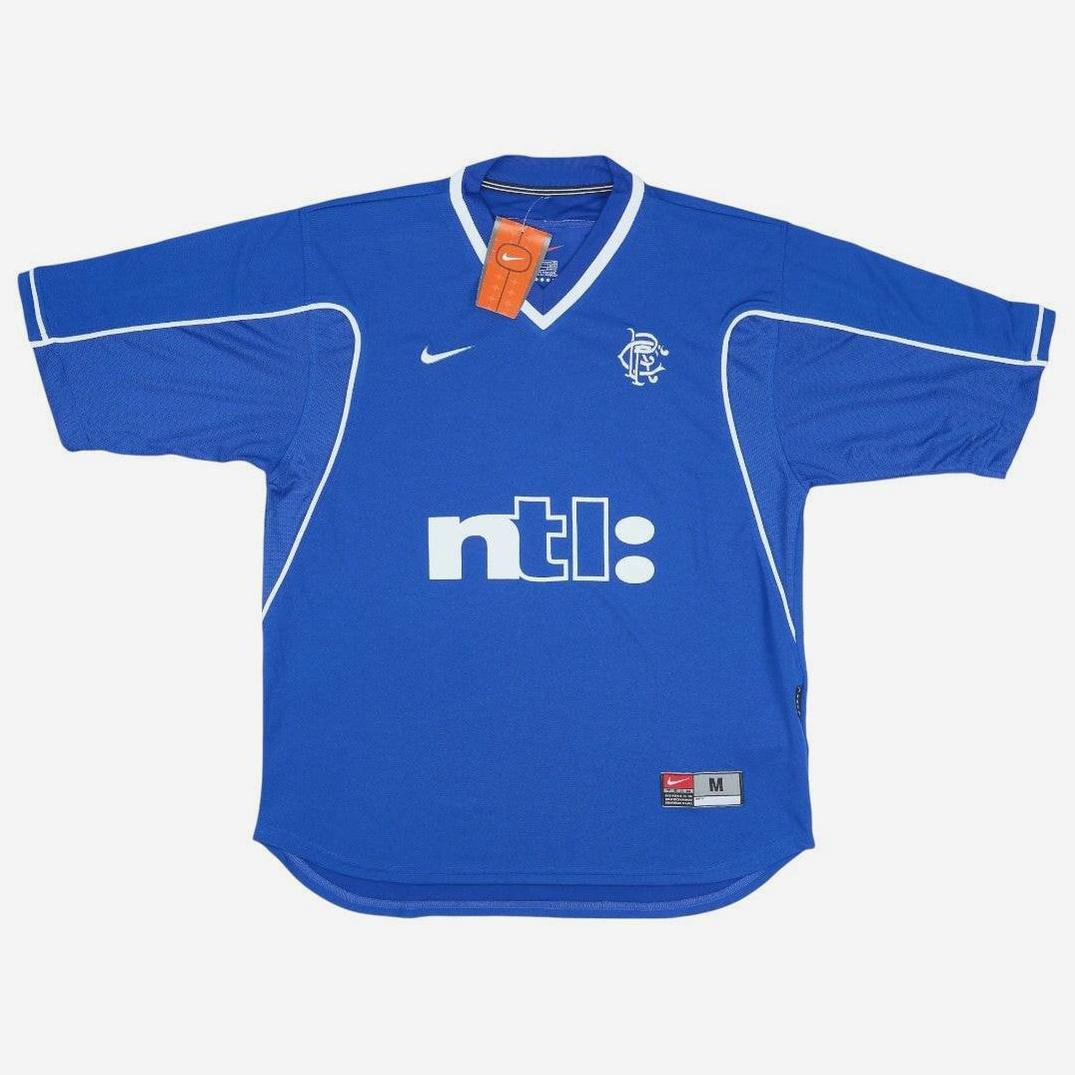 The Retro1999 Rangers F.C. 1999-01 Home Shirt in blue features white piping, iconic crest, Nike logo, and ntl: sponsor. Collared with a red Nike tag and labeled size M—this shirt is a classic piece of football heritage.