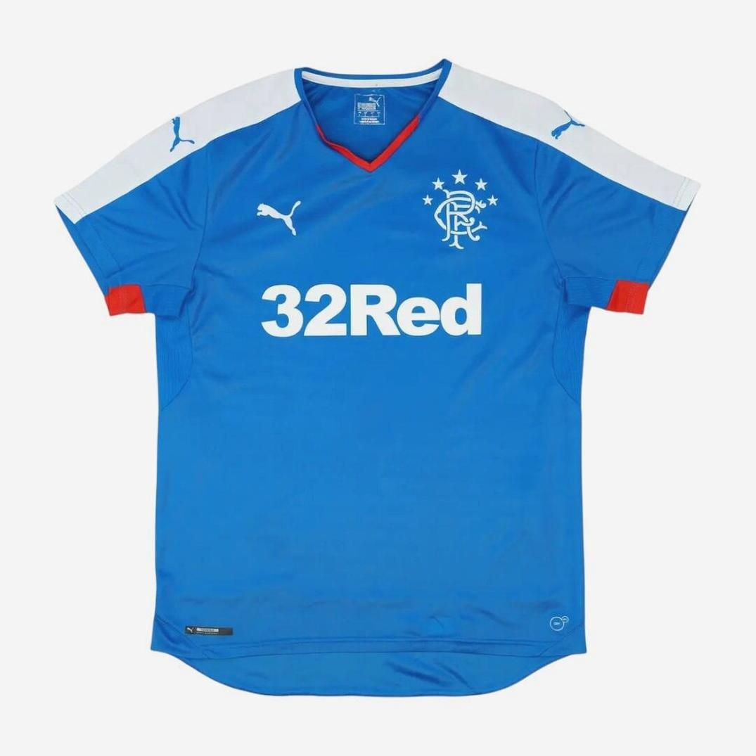 The Retro1999 Rangers F.C. 2015-16 Home Shirt showcases blue fabric, white shoulder panels and Puma logos, iconic crest with five stars, red sleeve cuffs, and the 32Red sponsor—ideal for fans of this classic retro kit.