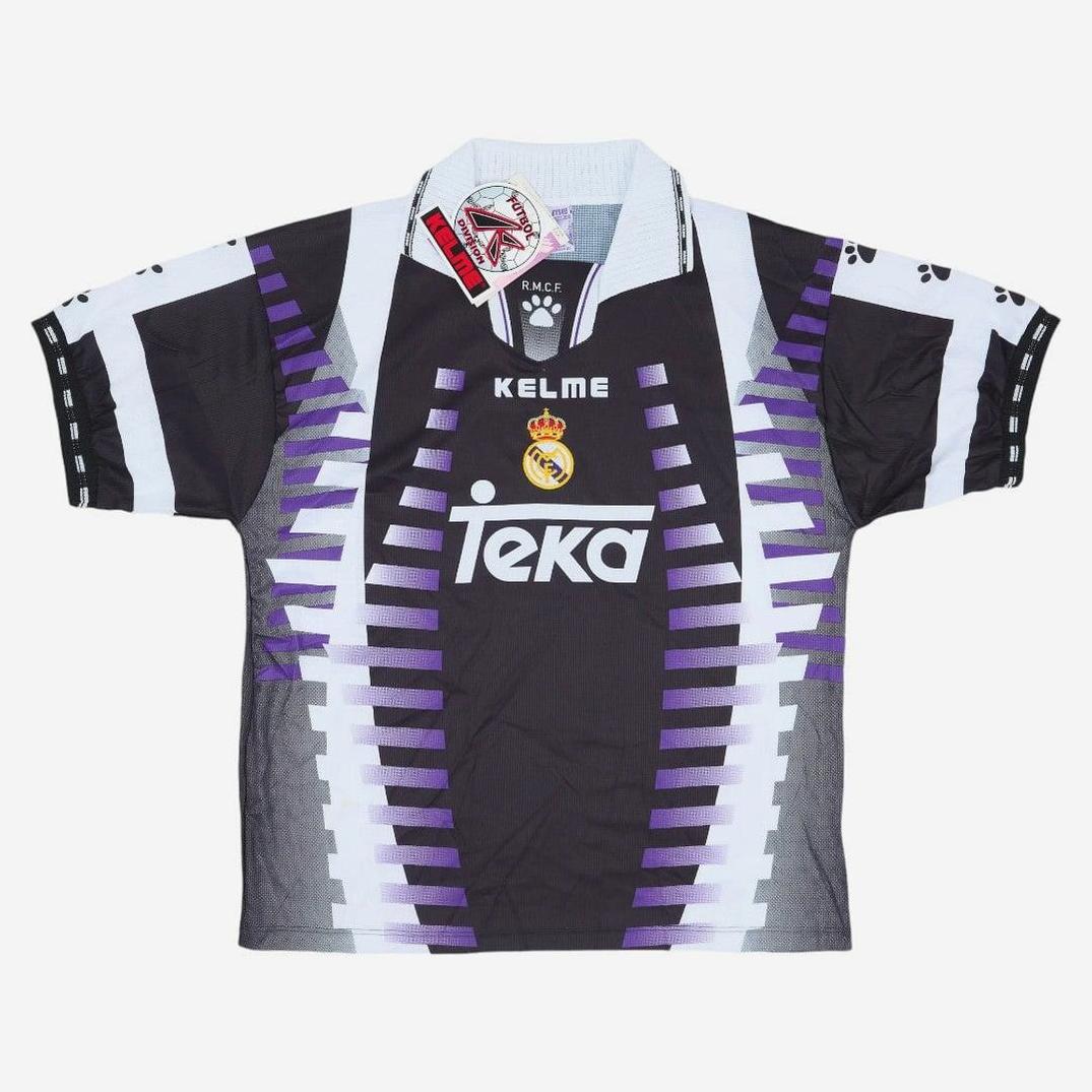 The Real Madrid 1997-98 Third Shirt by Retro1999 features black, white, and purple geometric patterns, a Teka sponsor logo, iconic crest, and light blue collar with tag—perfect for football fans and collectors.