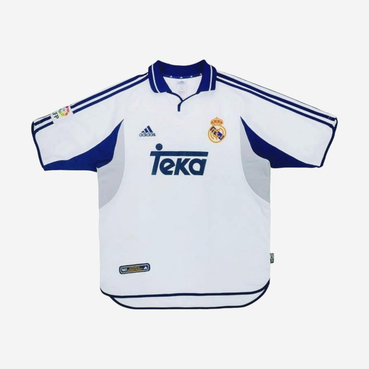 The Real Madrid 2000-01 Home Shirt by Retro1999 is a classic white jersey with blue accents, Adidas and Teka logos, plus the club crest—an iconic retro kit inspired by the La Liga 2000-01 season.
