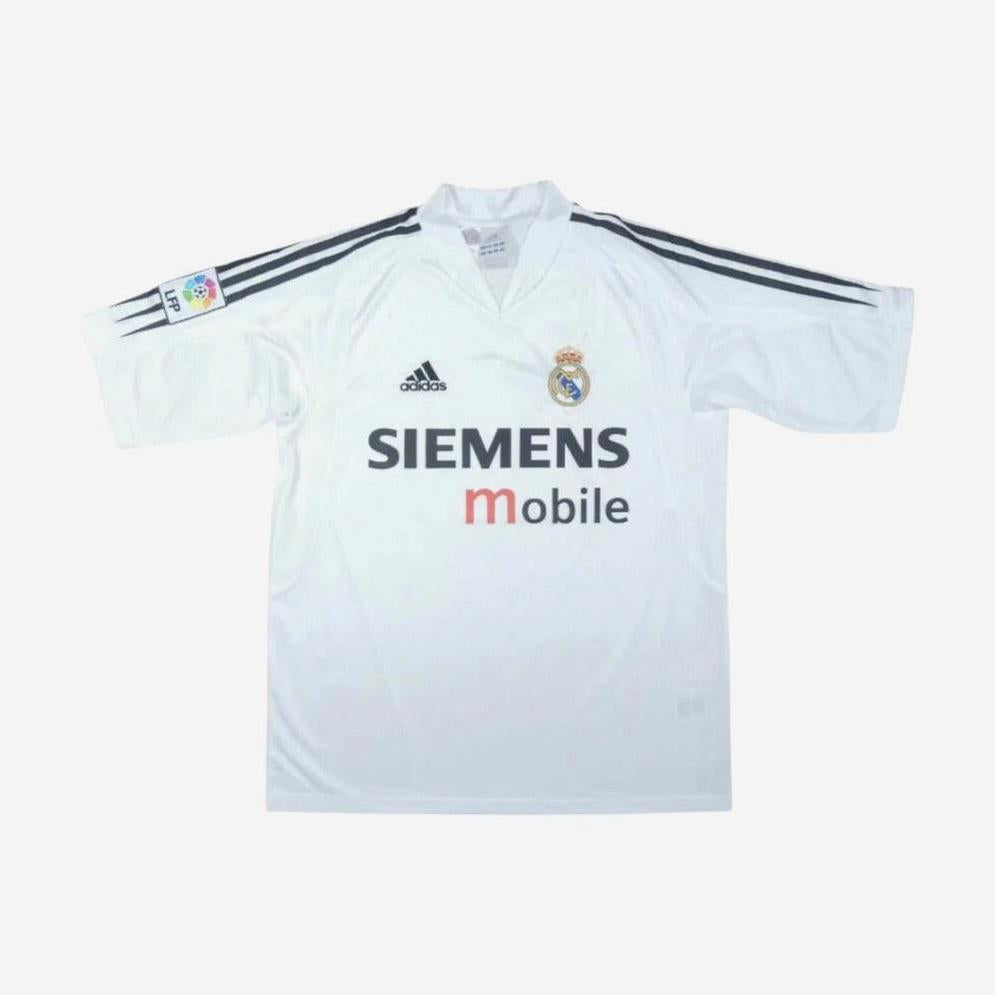 The Retro1999 Real Madrid 2004-05 Home Shirt features classic white design with black Adidas stripes, club crest, SIEMENS Mobile sponsor, and La Liga patch—a must-have retro kit for any sports memorabilia collection.