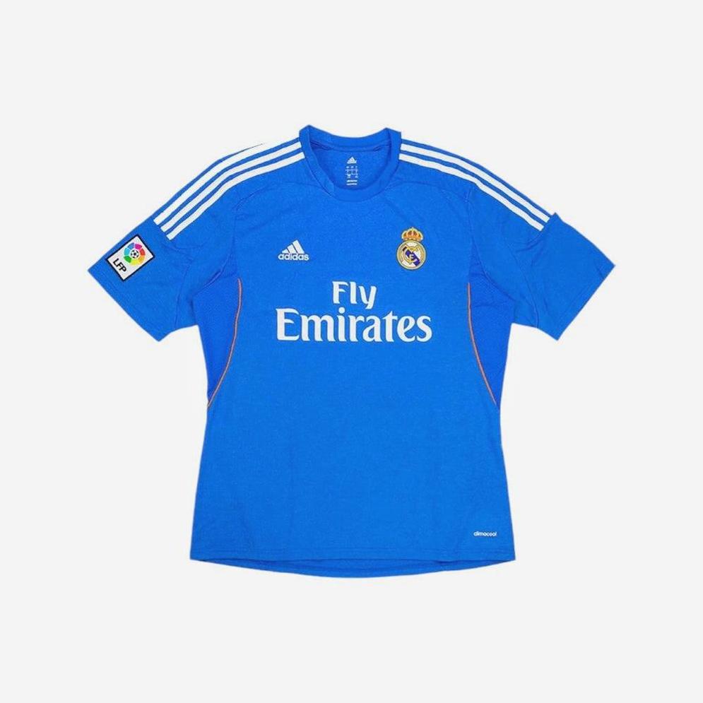 The Retro1999 Real Madrid 2013-14 Away Shirt is a blue classic with white Adidas stripes, “Fly Emirates” sponsor, club crest, and La Liga patch—a must-have retro kit for true football fans.
