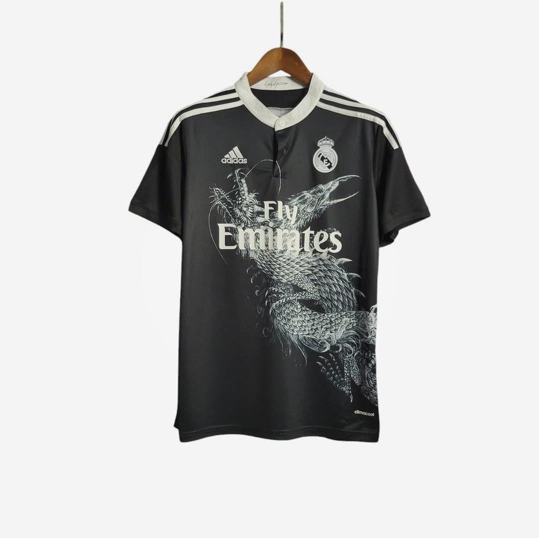 The Retro1999 Real Madrid 2014-15 Third Shirt, known as the Dragon Shirt, is black with white stripes, a dragon graphic, Adidas and club logos, and Fly Emirates sponsor text, shown on a wooden hanger against a white background.