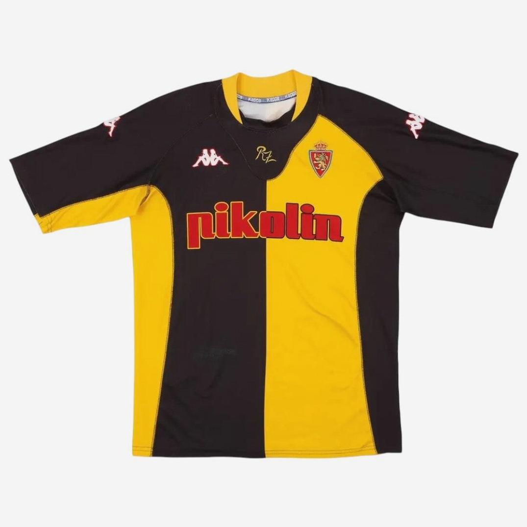 The Retro1999 Real Zaragoza 2001-02 Away Shirt is a black and yellow, short-sleeved soccer jersey with red pikolín text, Kappa shoulder logos, and a crowned crest—a classic retro design.