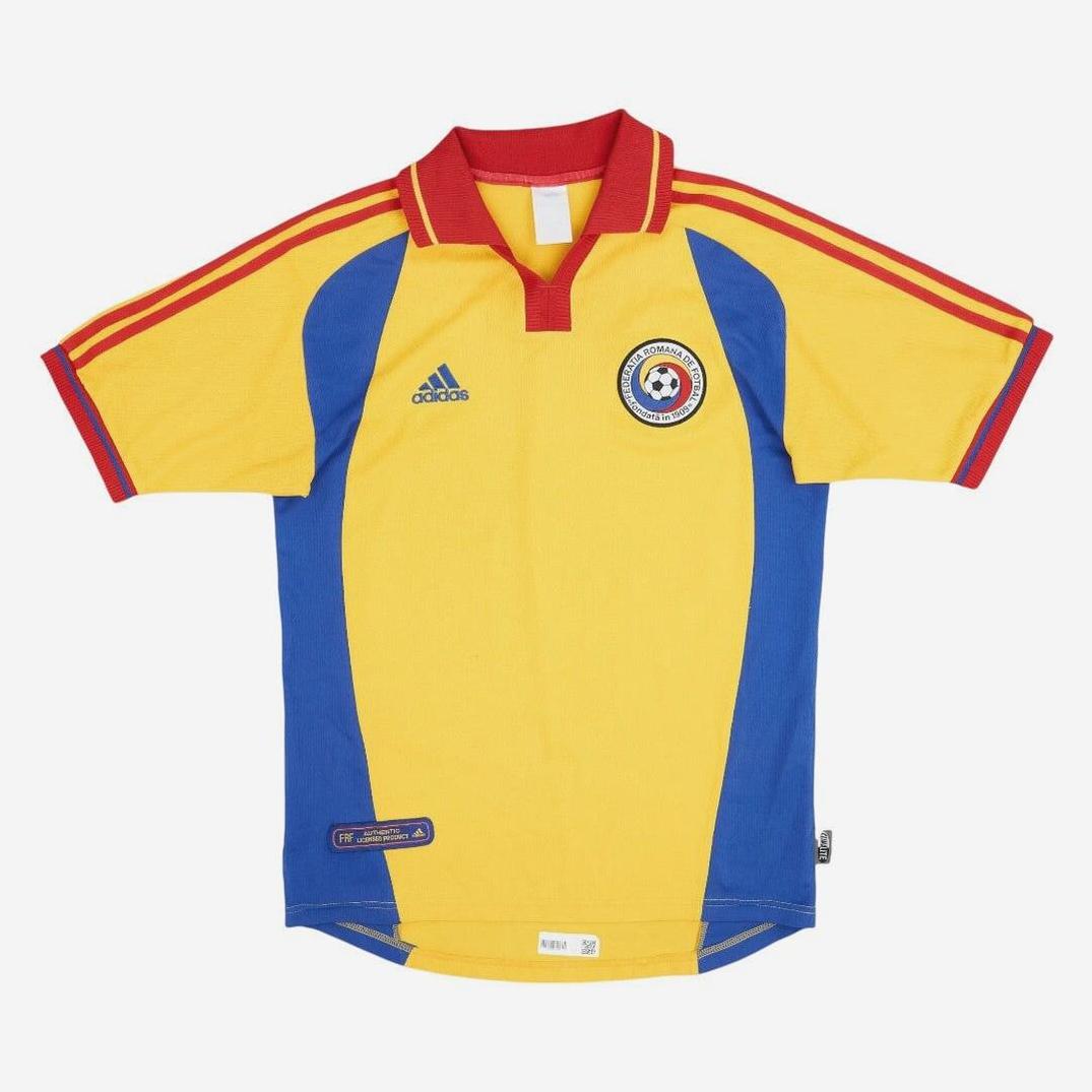 The Romania 2000 Home Shirt by Retro1999 features yellow and blue colors, red accents, a red collar with yellow trim, three red shoulder stripes, and the national crest—a tribute to Romania’s football heritage.