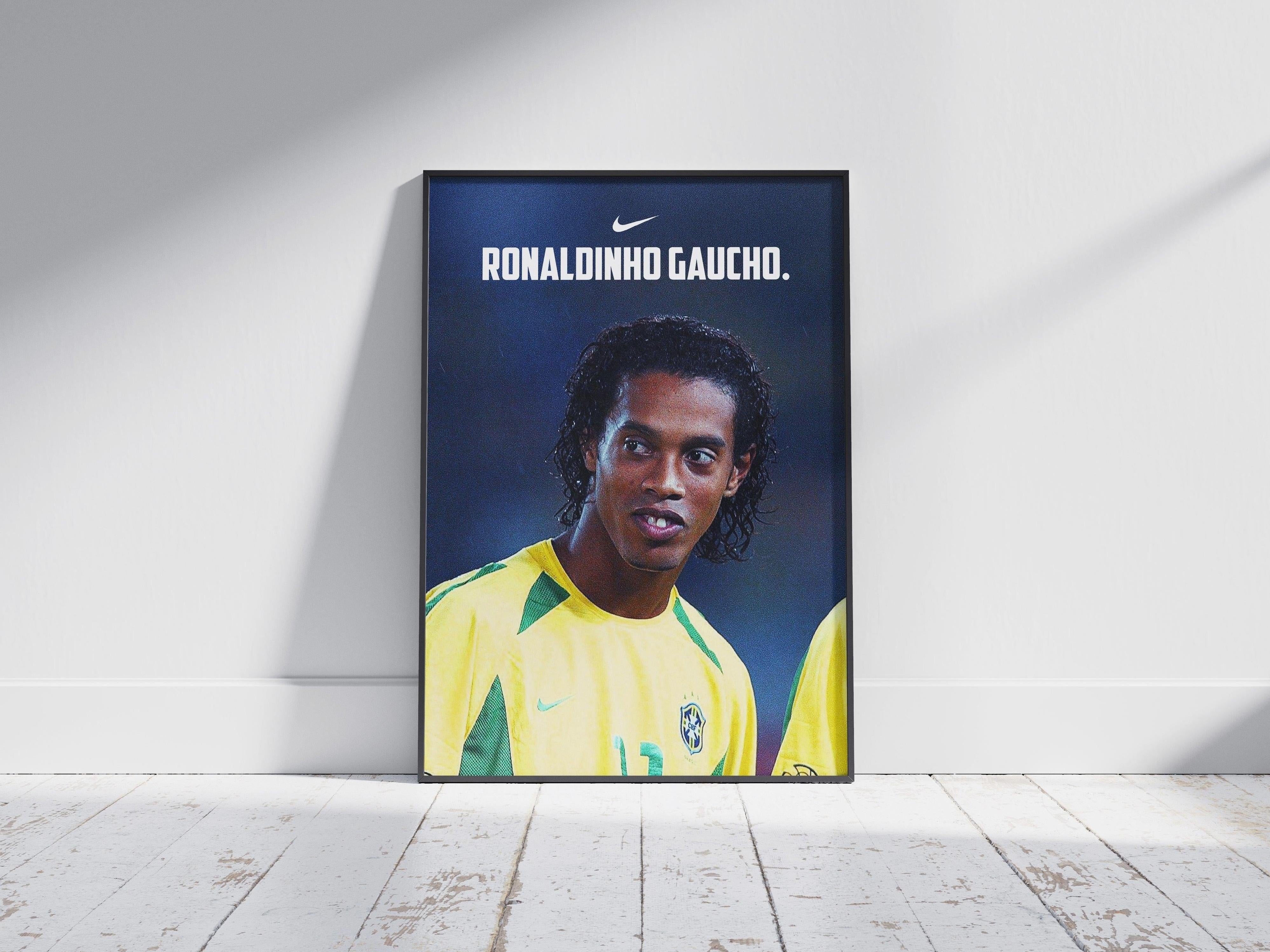 The Retro1999 Ronaldinho Gaucho 2002 Poster shows the soccer legend in a yellow Brazil jersey with Nike logo, framed and leaning on a white wall—ideal FIFA World Cup memorabilia for fans.
