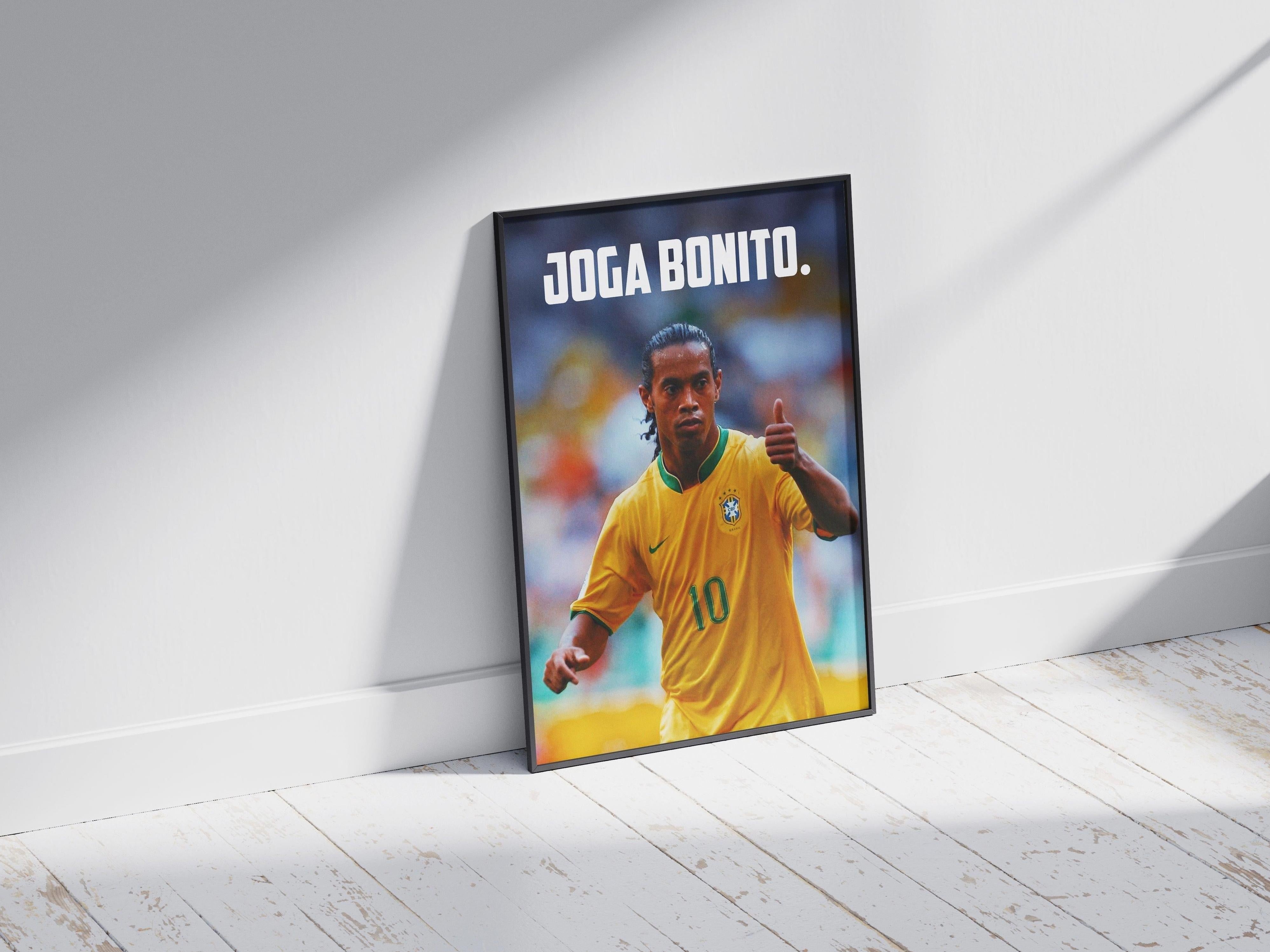 The Retro1999 Ronaldinho Joga Bonito Poster features the Brazilian soccer icon in a yellow #10 jersey, giving a thumbs up on a wooden floor, with bold white JOGA BONITO. at the top recalling FIFA World Cup 2006 flair.