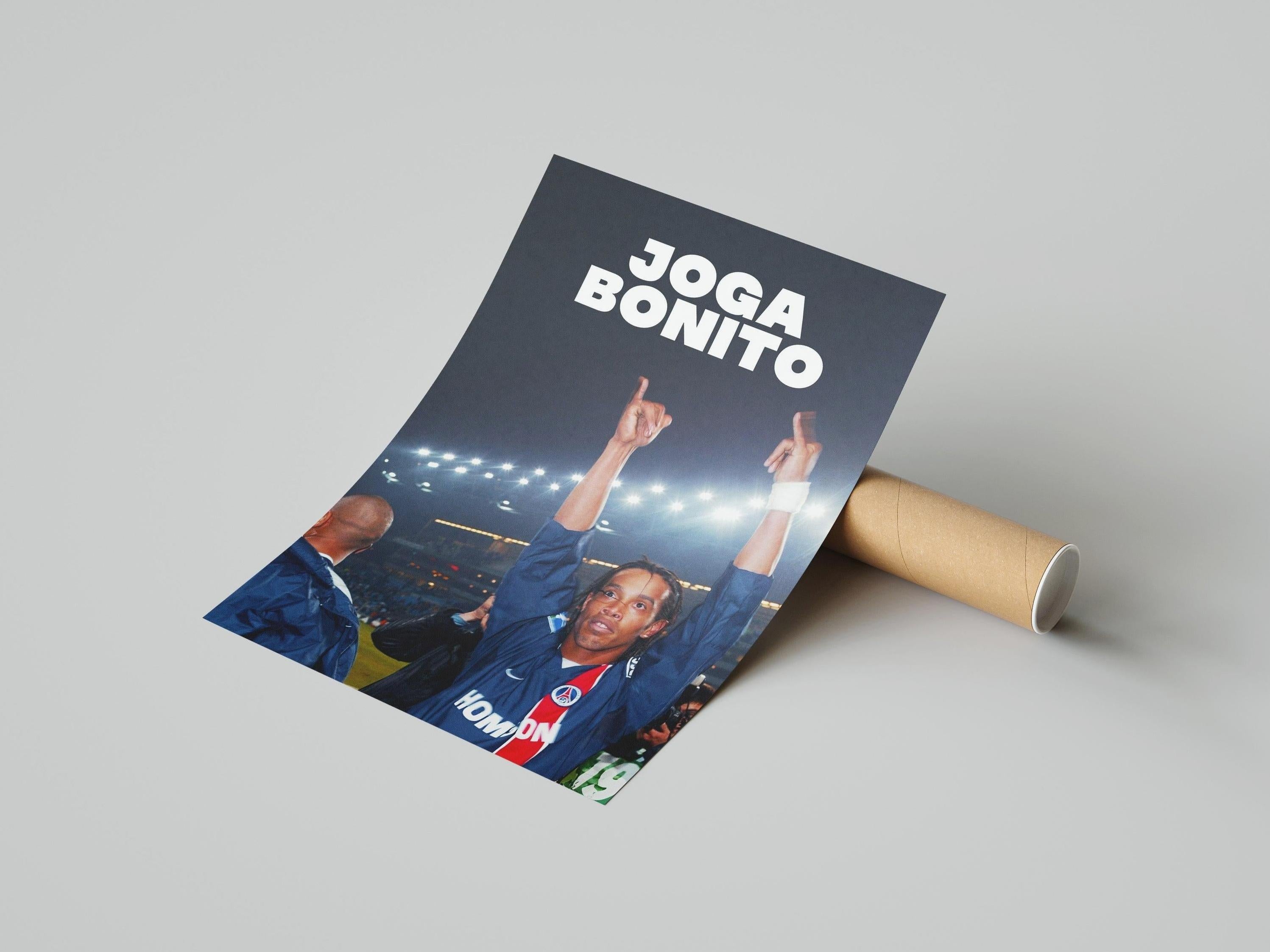 The Retro1999 Ronaldinho Joga Bonito Poster shows the soccer legend in a blue jersey celebrating under stadium lights, with JOGA BONITO at the top—perfect for fans of football history. Poster is partially unrolled from a tube.