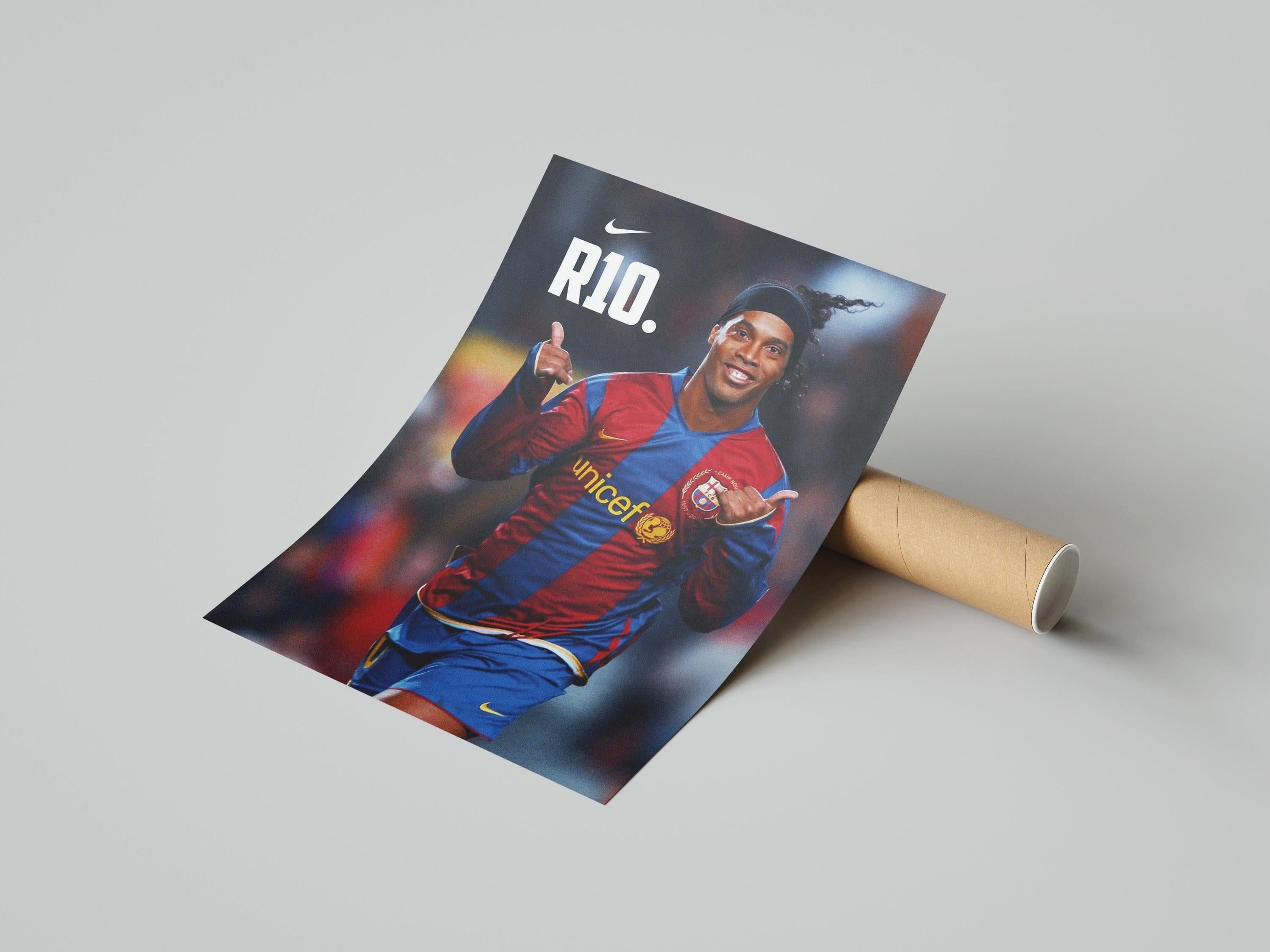 The Retro1999 Ronaldinho R10 Poster shows the soccer star in a red and blue jersey, smiling and giving a thumbs up with RIO. and the Nike logo above him on a light gray background—ideal as sports decor or a collectible.