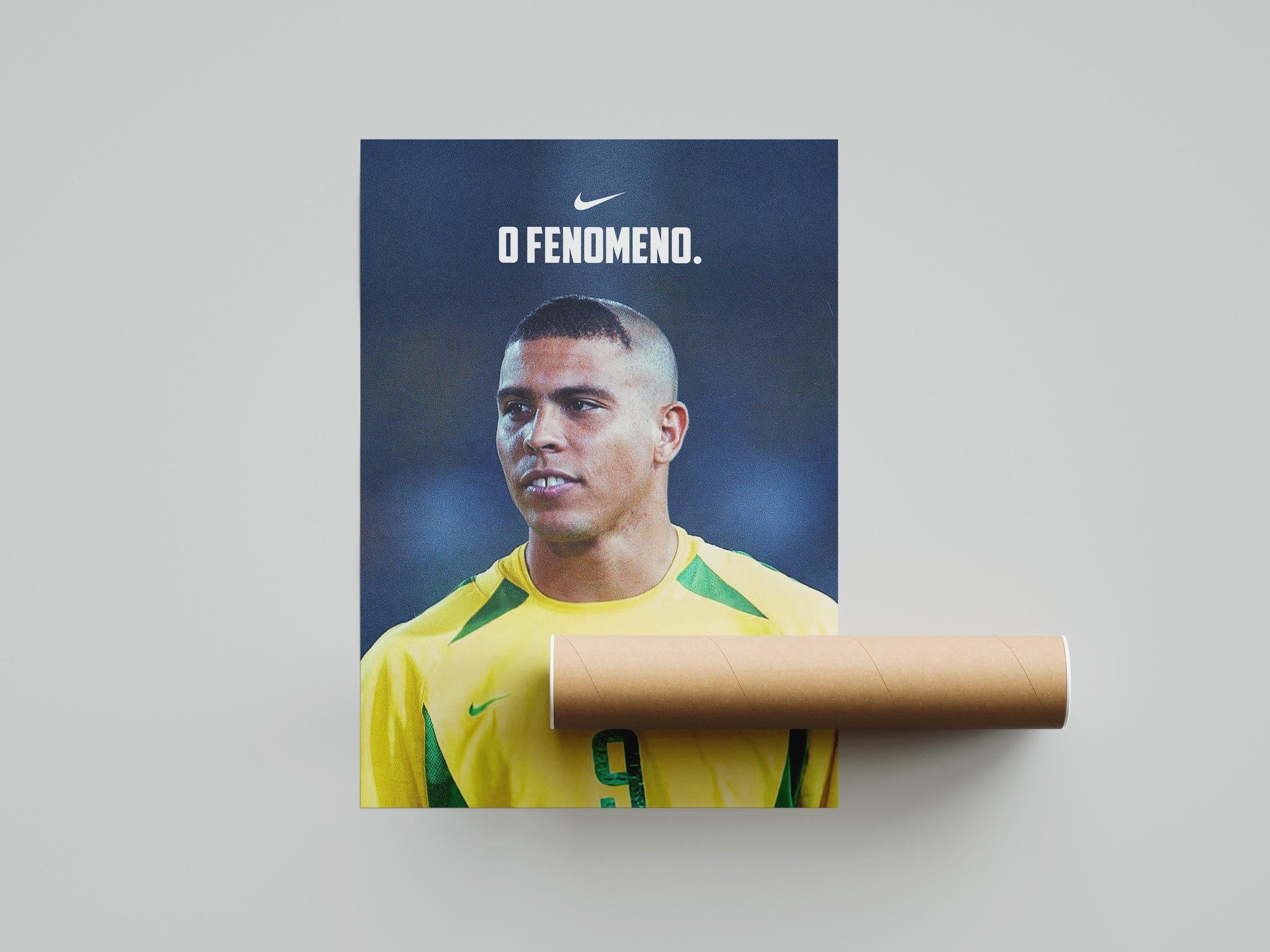The Retro1999 Ronaldo O Fenômeno Poster showcases Ronaldo in a yellow #9 jersey with his iconic haircut and the text O Fenomeno, plus a Nike logo. A must-have for FIFA World Cup 2002 fans. Includes cardboard tube, bottom right.