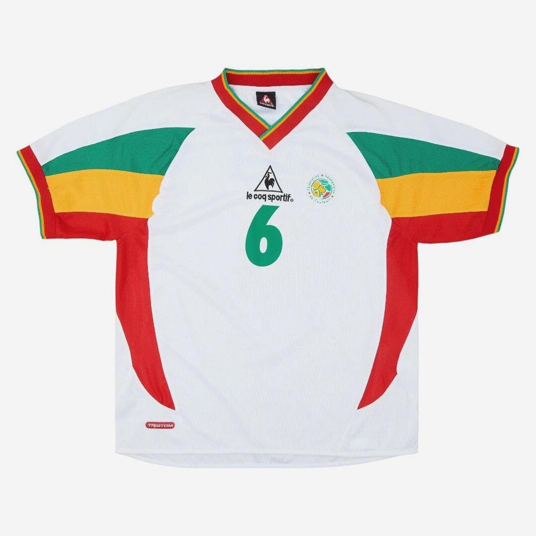 The Retro1999 Senegal 2002 Home Shirt is white with red, yellow, and green sleeve stripes, number 6 on the front, and features classic logos—ideal for fans of vintage football kits and Senegalese football heritage.