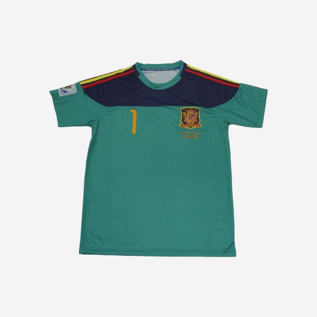 The Retro1999 Spain 2010 Blue Goalkeeper Shirt features short sleeves, a yellow number 1, national team crest, navy chest panel, and retro-inspired red and yellow shoulder stripes—perfect for football fans.