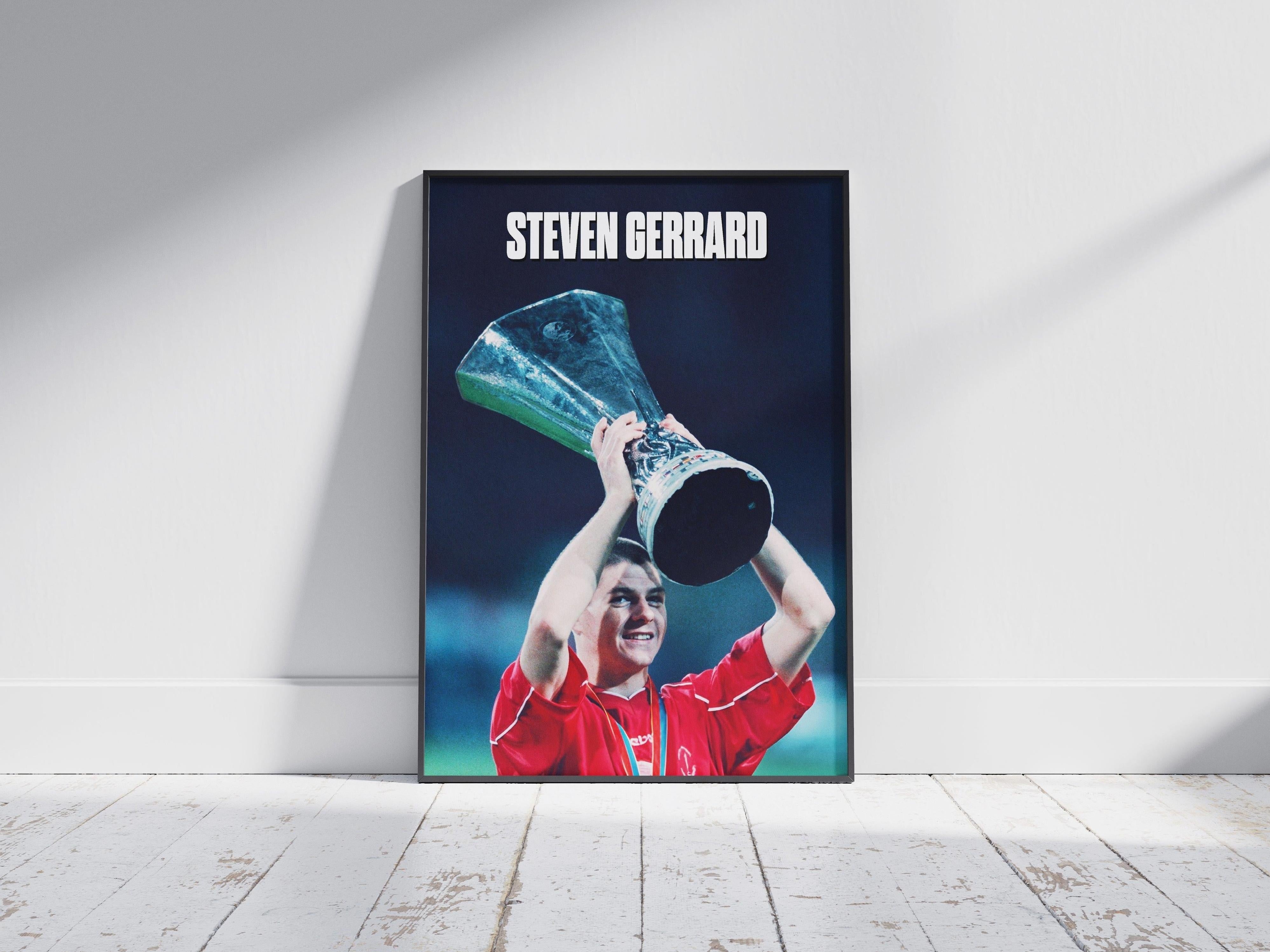 The Steven Gerrard x Champions League Poster by Retro1999 depicts Gerrard in a red jersey lifting the trophy, with his name in bold white letters, celebrating Liverpool FC’s iconic victory.