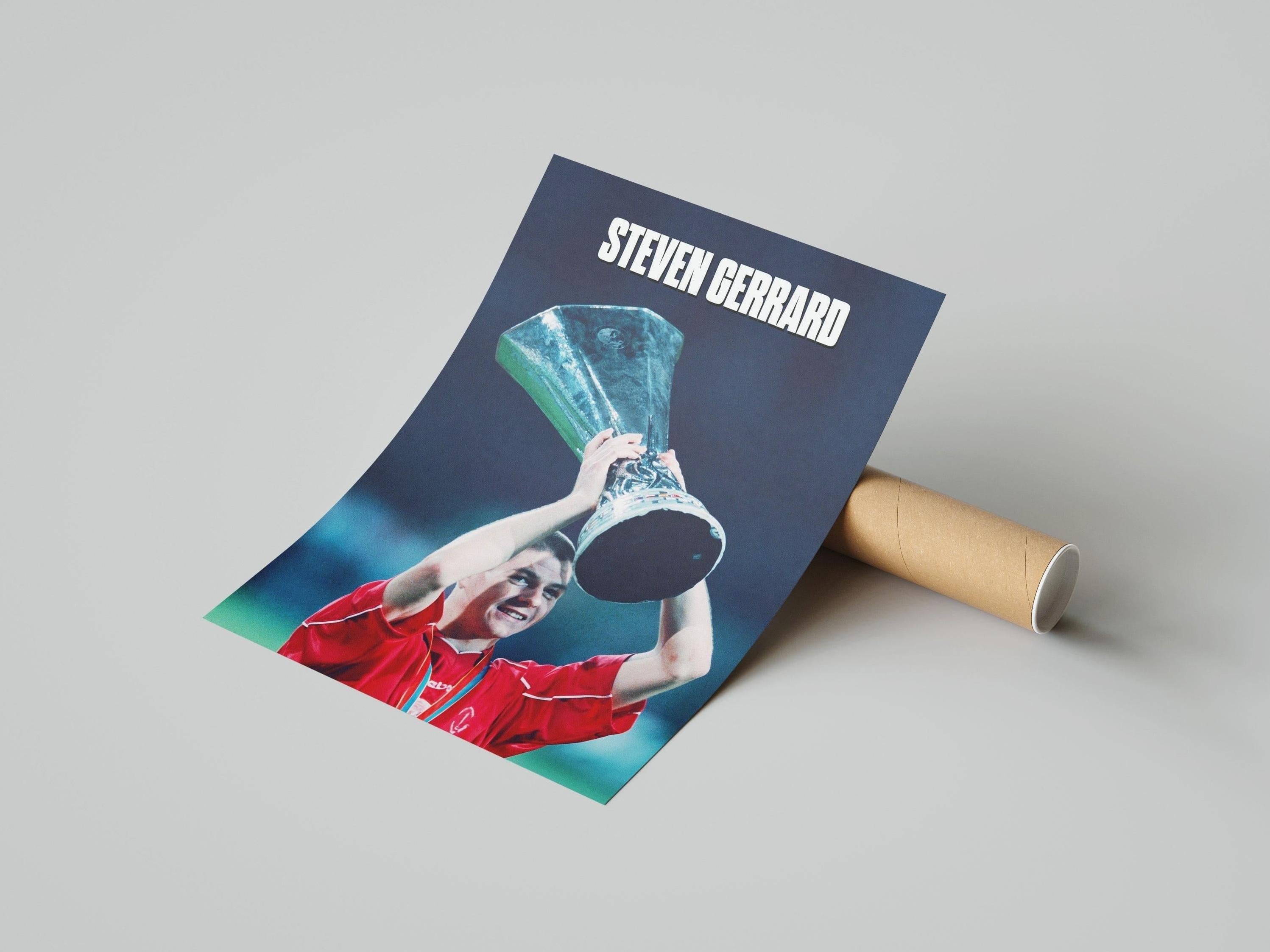 The Retro1999 Steven Gerrard x Champions League Poster shows Gerrard in a red kit lifting the Champions League trophy, with his name in bold white letters at the top. Arrives rolled up and ready to display.