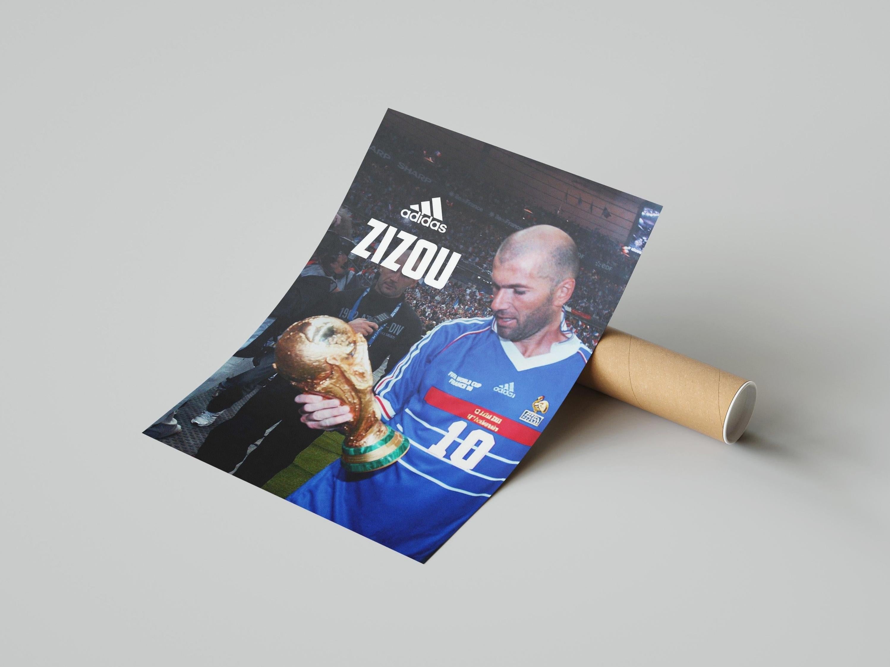 The Retro1999 Zinedine Zidane Zizou Poster shows Zidane in a blue France jersey holding the FIFA World Cup trophy, with ADIDAS ZIZOU at the top and partially rolled out from a cardboard tube.